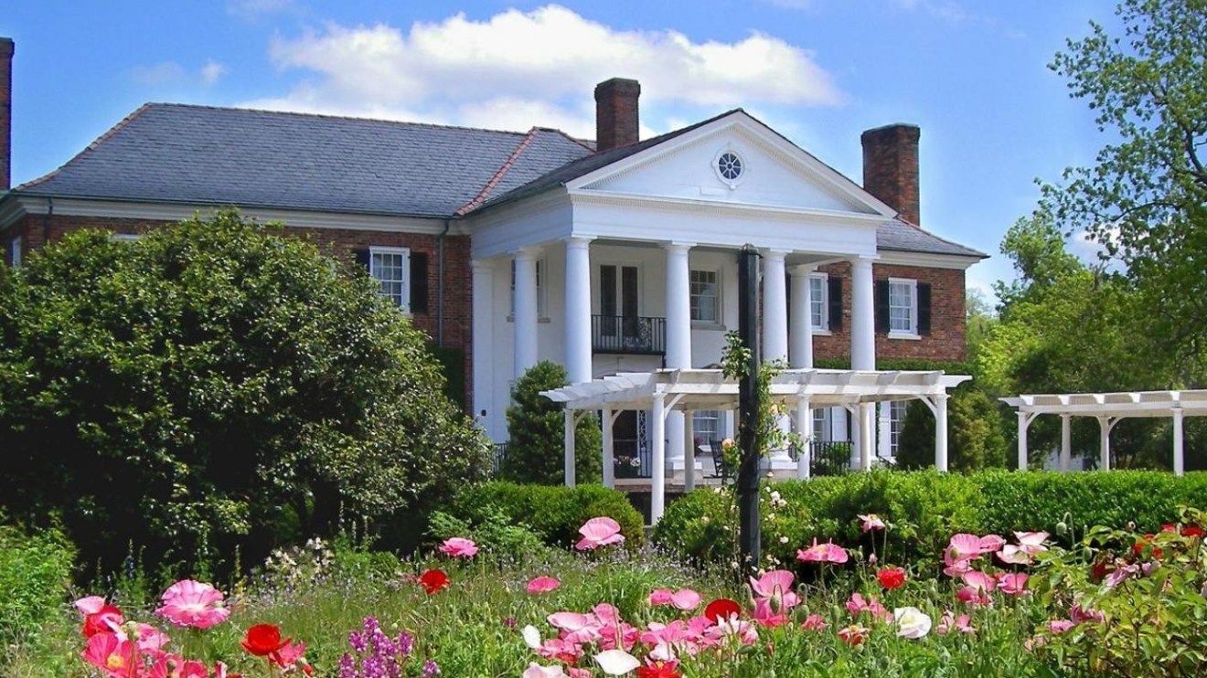 a close up of a flower garden in front of a house