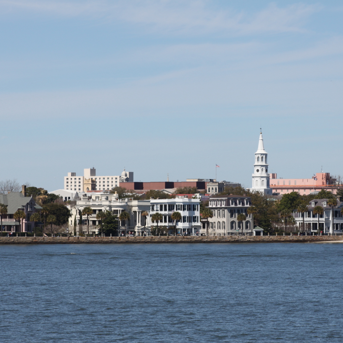 Coastal cityscape with historic buildings and a church spire.