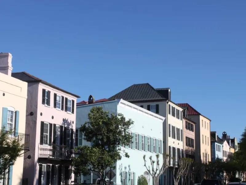 Colorful row of pastel houses under a clear blue sky.